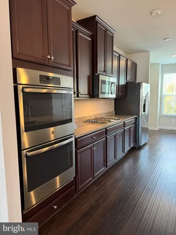 a kitchen with stainless steel appliances granite countertop a stove microwave and refrigerator