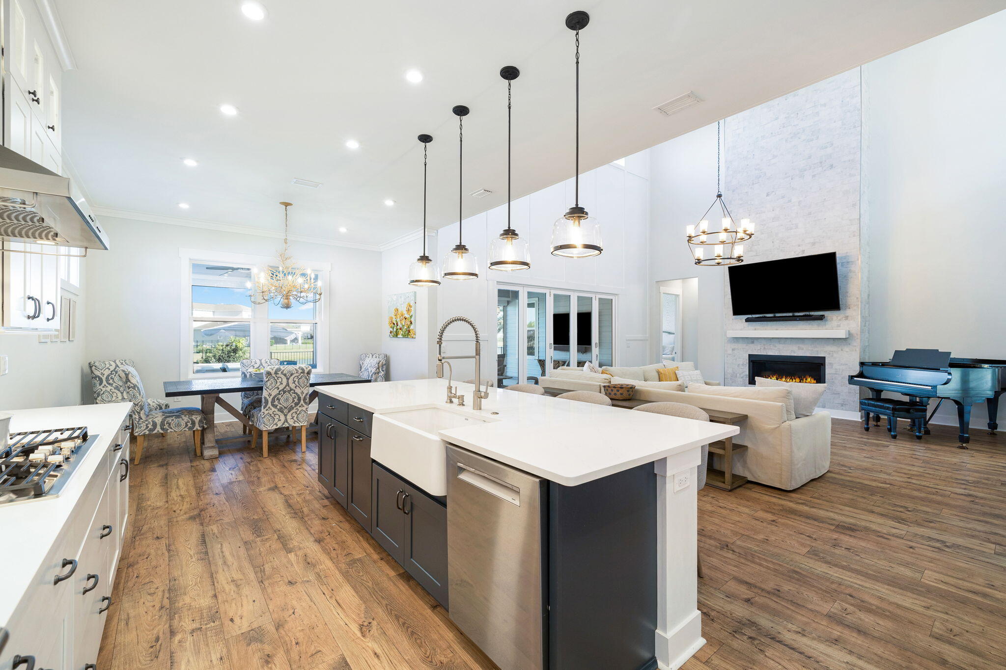 56 River Rise Way Inlet Beach Inlet Beach, FL 32461 - Photo 19 of 69 a large white kitchen with a large island a sink dishwasher a dining table and chairs with wooden floor