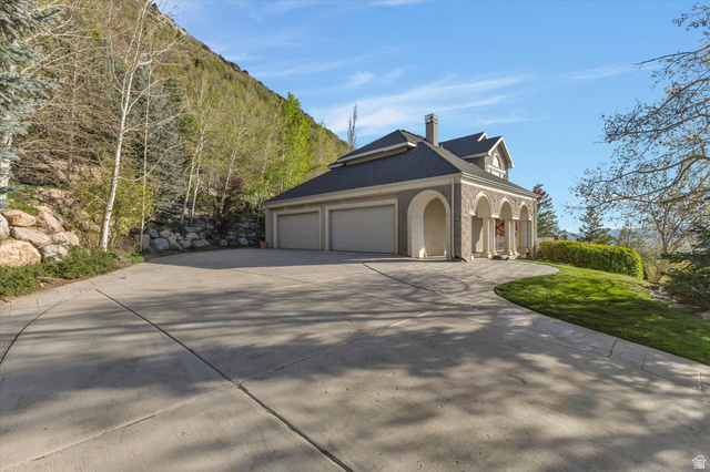 3222 Eagle View Circle Sandy, UT 84092 - Photo 54 of 60 View of property exterior featuring a chimney, driveway, a yard, and a garage