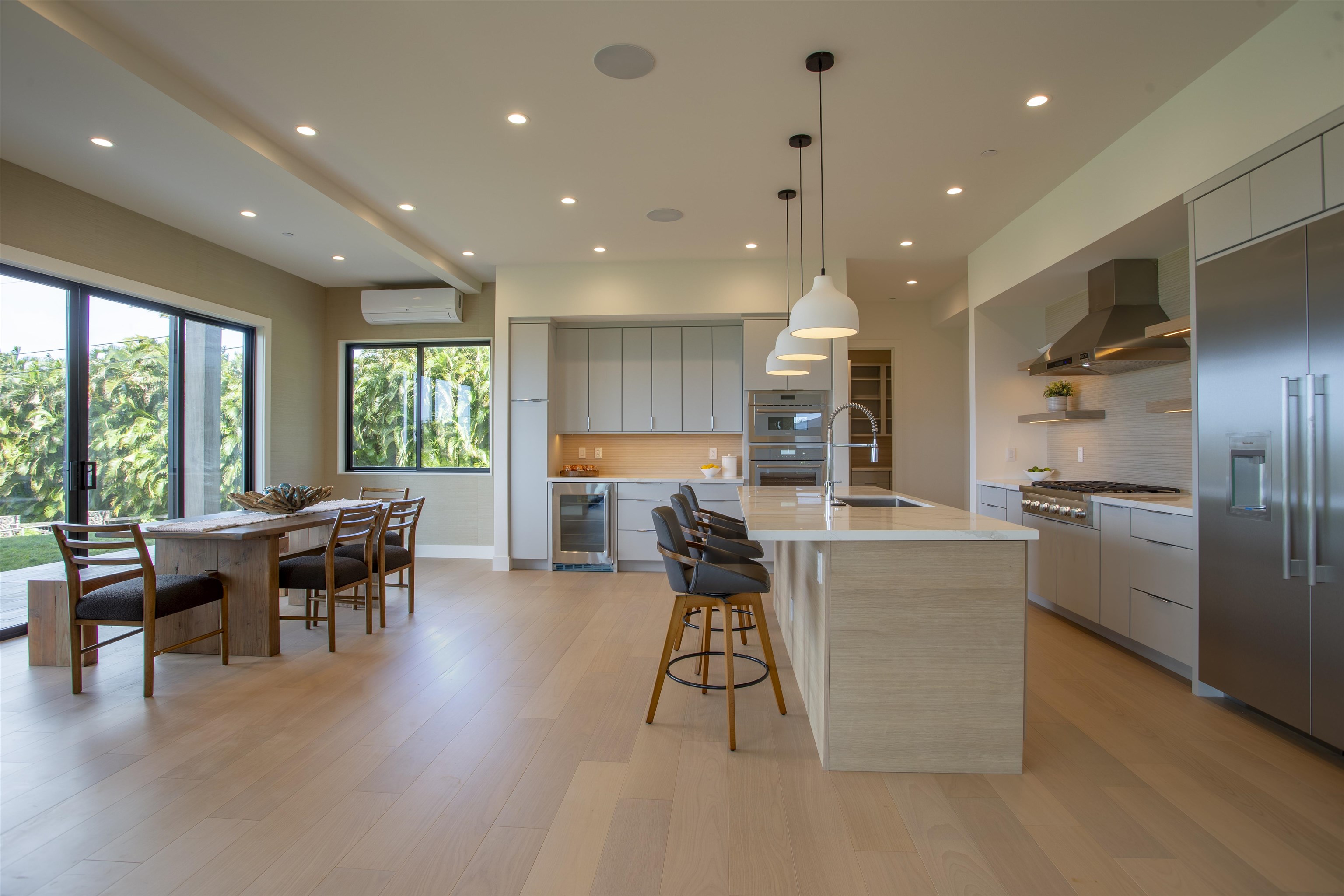 111 Mehana Road, Unit A Haiku, HI 96708 - Photo 10 of 41 a kitchen with stainless steel appliances kitchen island granite countertop a stove a refrigerator a sink a dining table and chairs with wooden floor