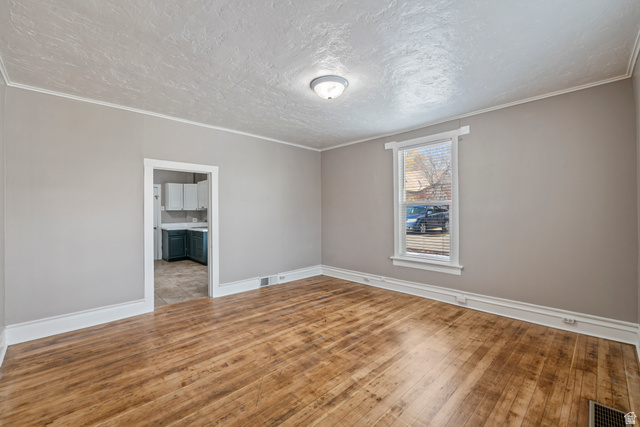 75 600 West Provo, UT 84601 - Photo 8 of 26 Spacious room with wood-finish flooring, light gray wall paint, and white trim