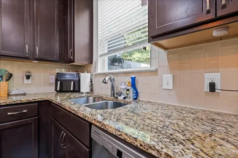 a kitchen with granite countertop sink and cabinets