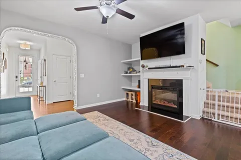 a living room with furniture a flat screen tv and a fireplace