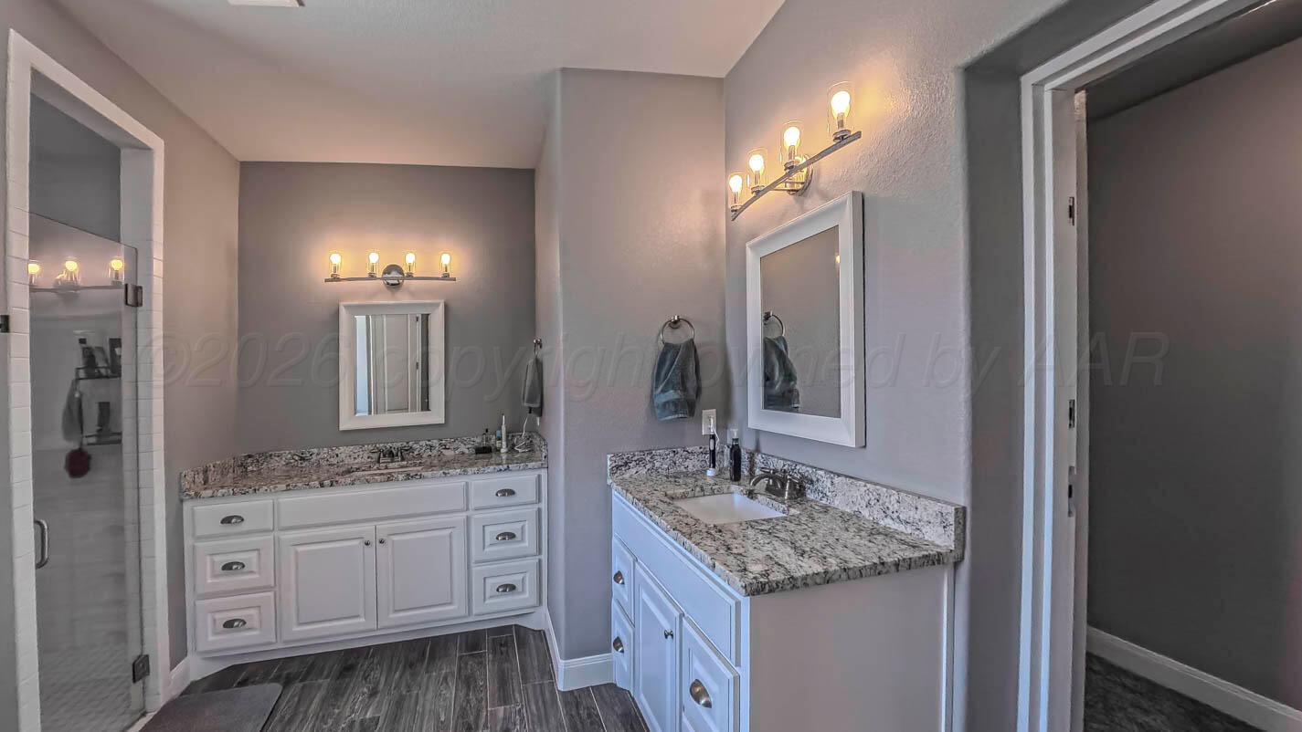 8903 Canton Court Amarillo, TX 79119 - Photo 16 of 26 a bathroom with a granite countertop sink and a mirror