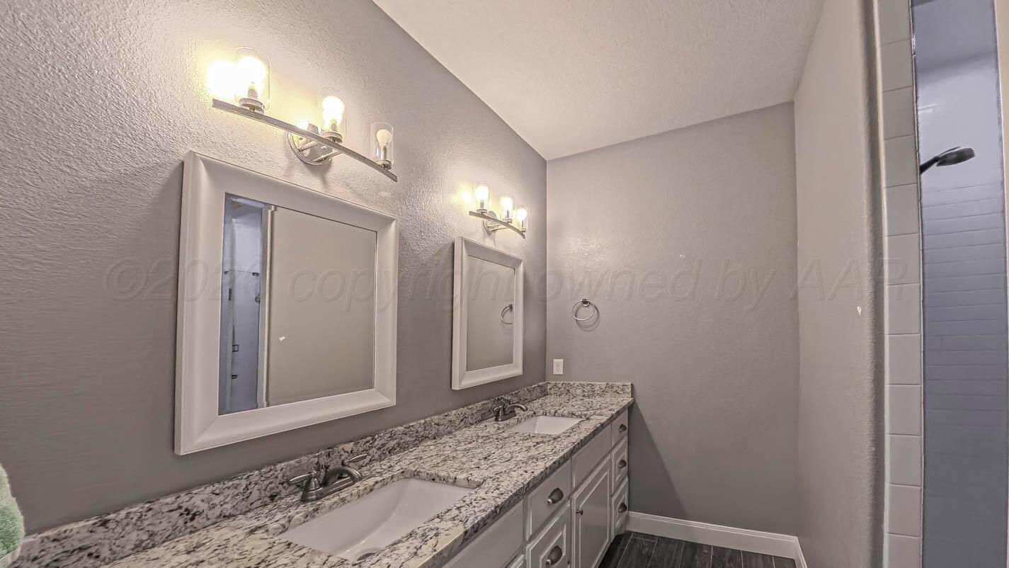 8903 Canton Court Amarillo, TX 79119 - Photo 24 of 26 a bathroom with a granite countertop sink and a mirror