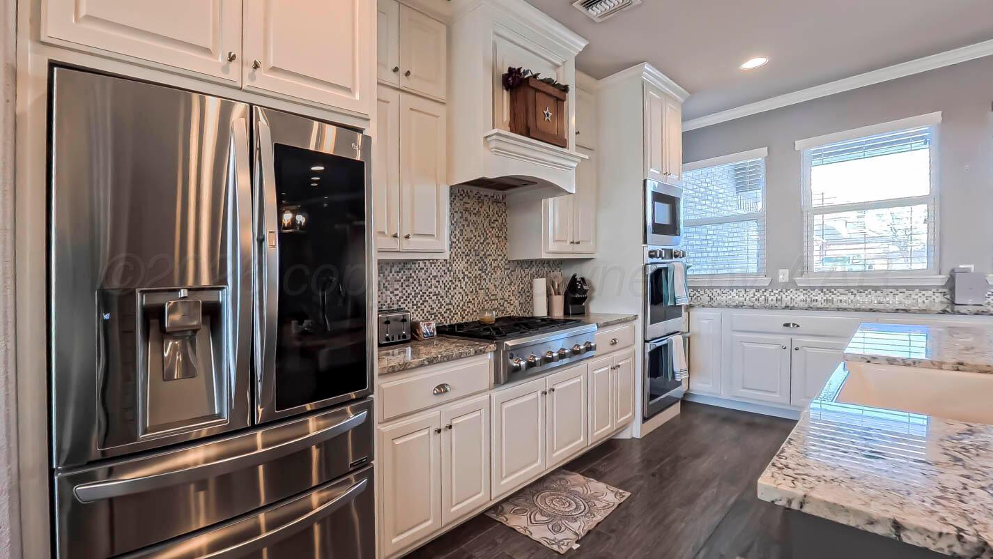 8903 Canton Court Amarillo, TX 79119 - Photo 6 of 26 a kitchen with granite countertop a refrigerator stove and sink