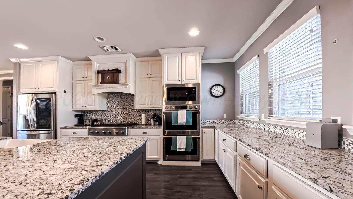 8903 Canton Court Amarillo, TX 79119 - Photo 7 of 26 a large kitchen with stainless steel appliances granite countertop a stove sink and cabinets