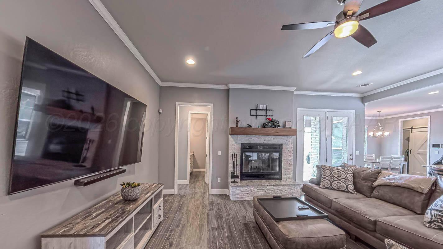 8903 Canton Court Amarillo, TX 79119 - Photo 9 of 26 a living room with furniture flat screen tv and a fireplace