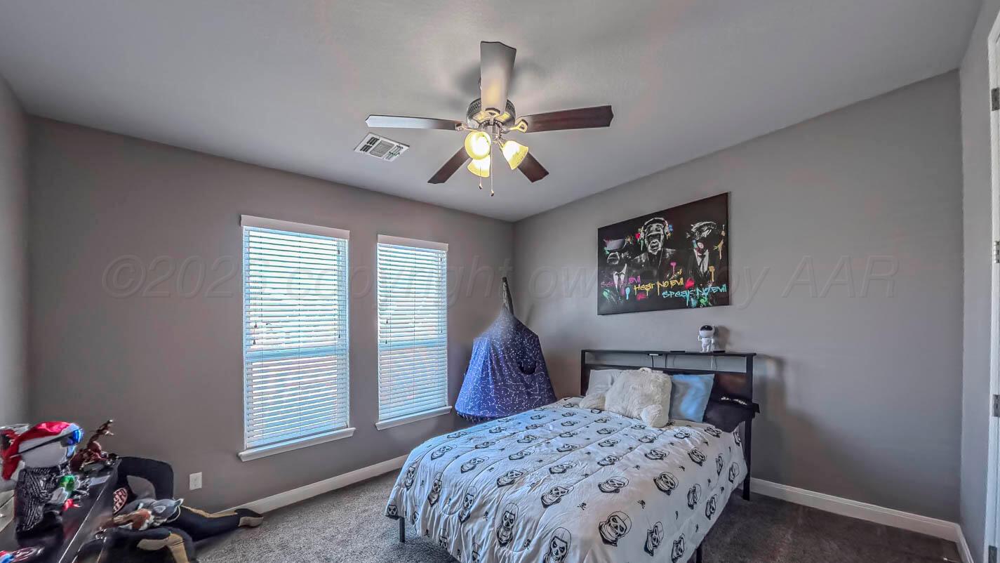 8903 Canton Court Amarillo, TX 79119 - Photo 10 of 26 a bedroom with a bed and a chandelier