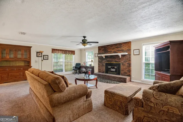 a living room with furniture a flat screen tv and a fireplace