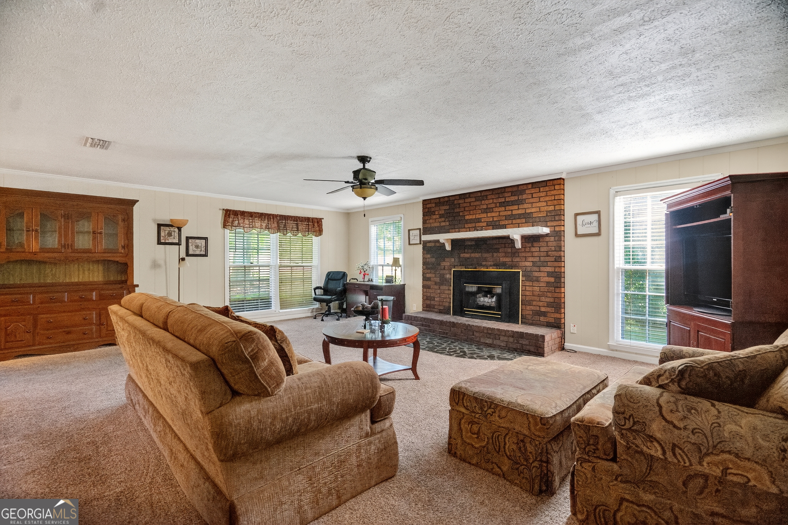 709 Vernon Ferry Road LaGrange, GA 30240 - Photo 7 of 27 a living room with furniture a flat screen tv and a fireplace