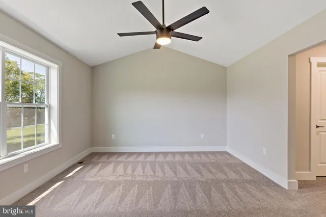 an empty room with a window and a fan