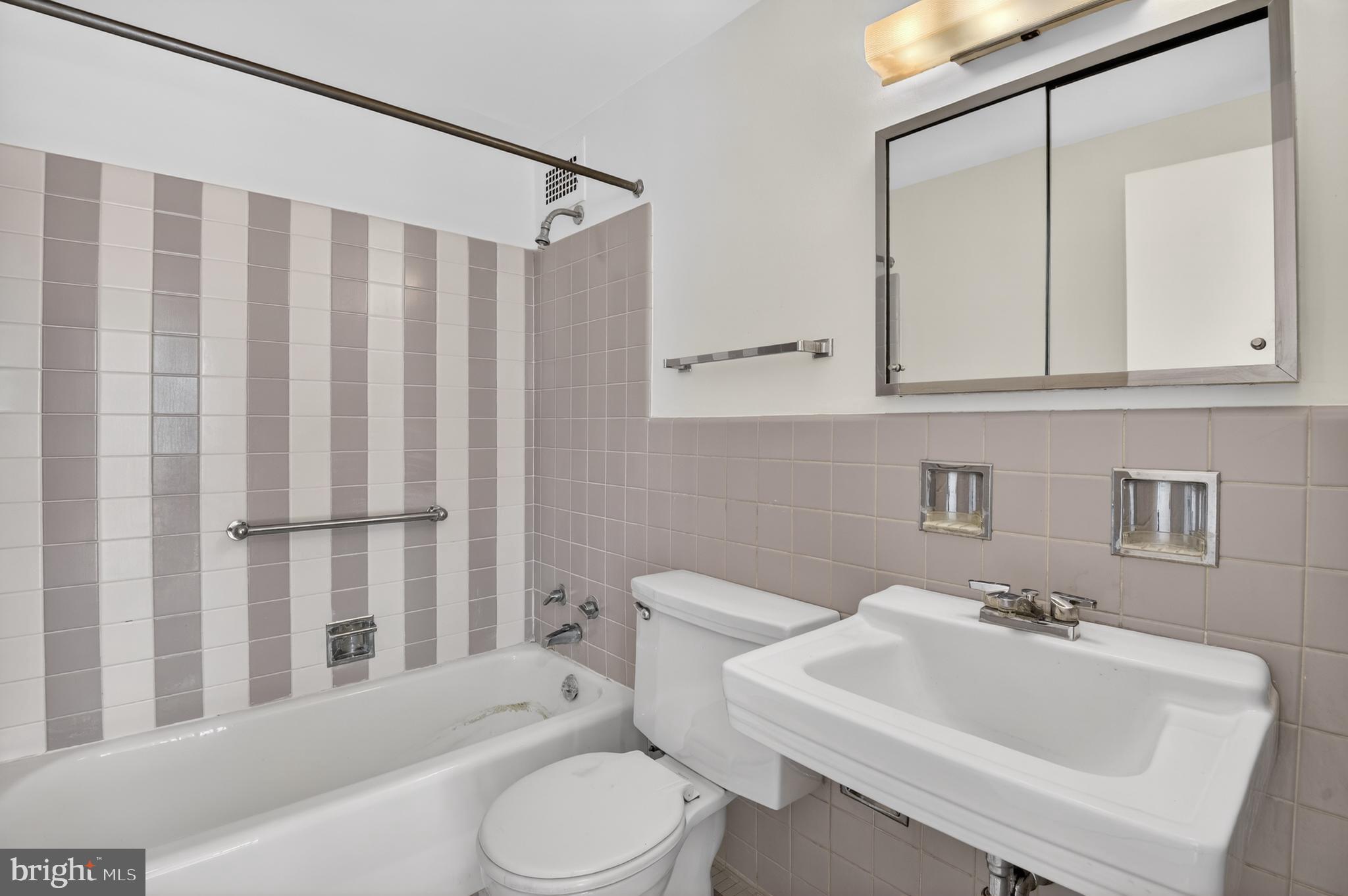 2475 Virginia Avenue Northwest, Unit 429 Washington, DC 20037 - Photo 21 of 35 a bathroom with a sink a toilet and shower curtain