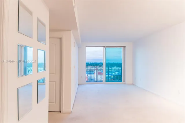 a view of a hallway with wooden floor and closet area