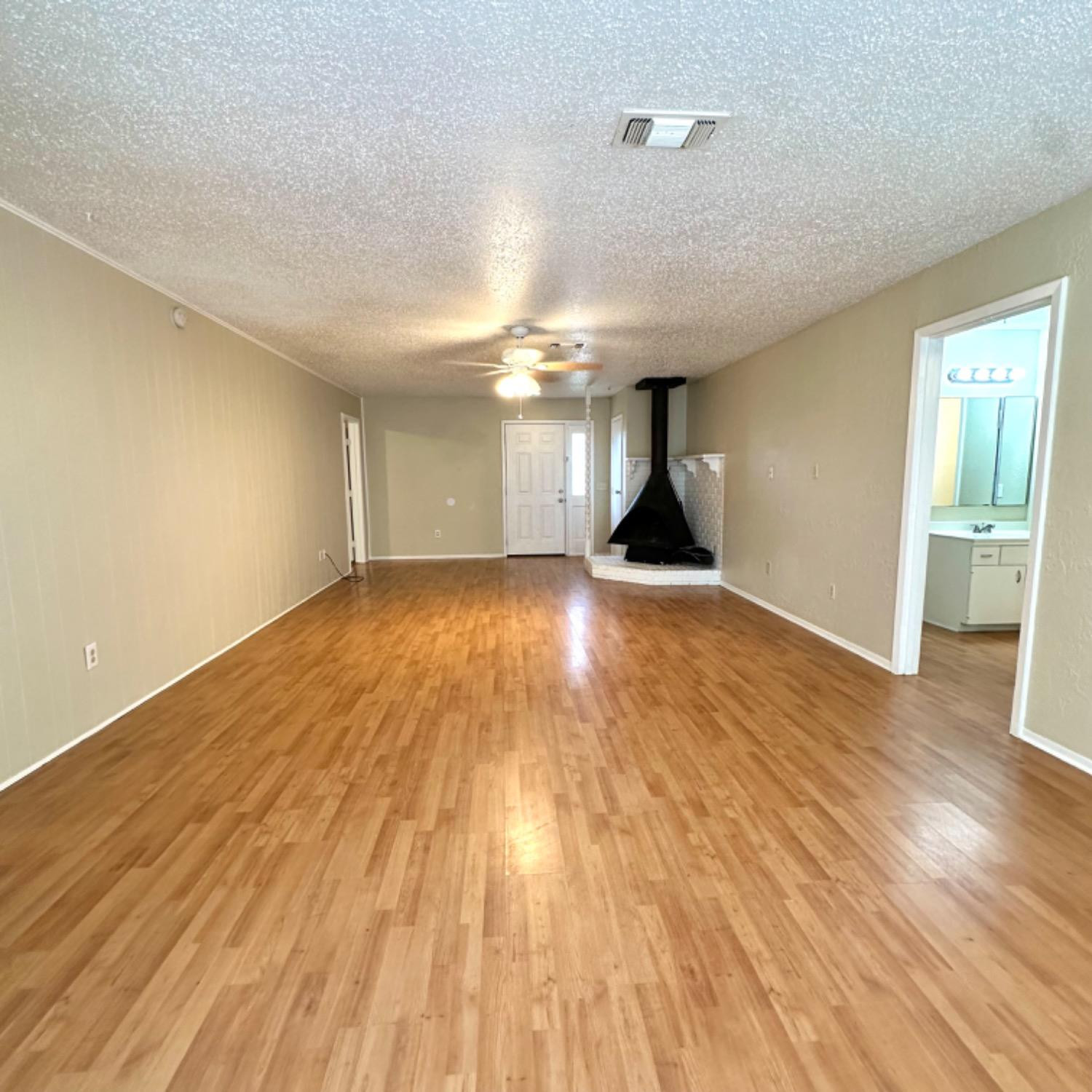 9107 Boston Avenue Lubbock, TX 79423 - Photo 3 of 14 a view of empty room with wooden floor and fan