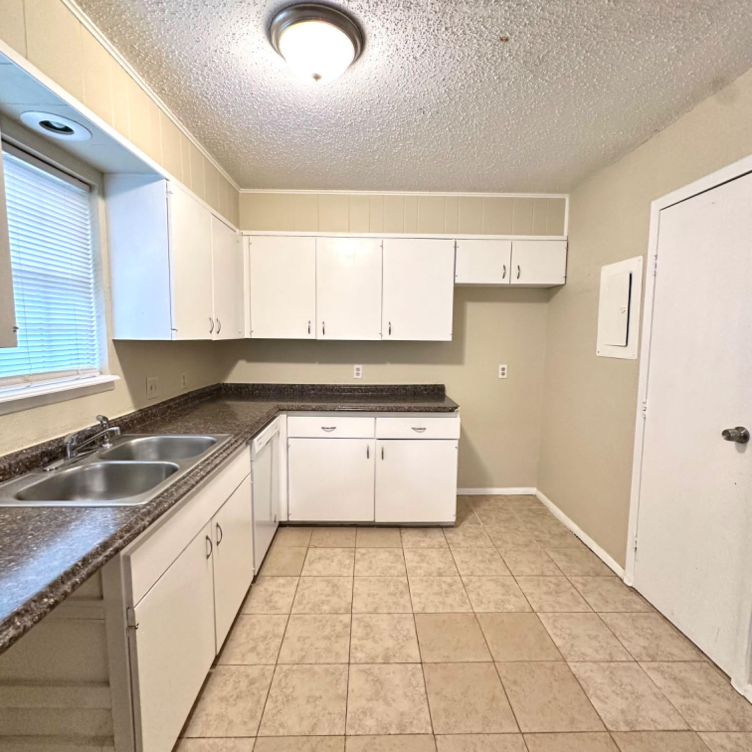 9107 Boston Avenue Lubbock, TX 79423 - Photo 5 of 14 a kitchen with a sink a stove cabinets and a window