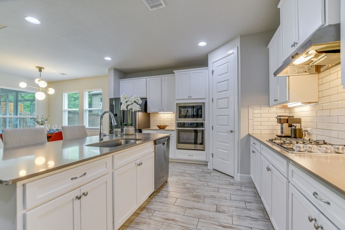 a kitchen with kitchen island granite countertop a sink counter top space appliances and cabinets
