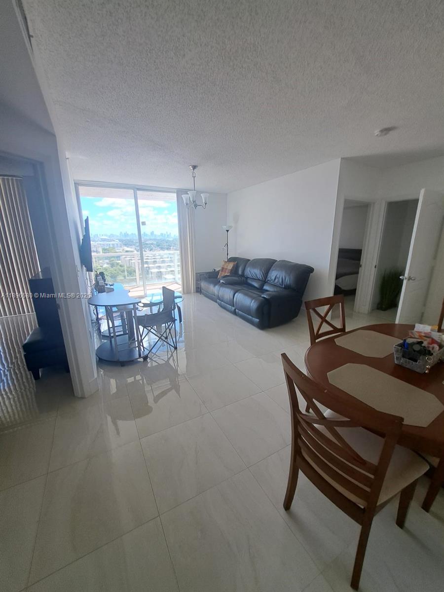 5077 Northwest 7th Street, Unit PH17 Miami, FL 33126 - Photo 2 of 25 a living room with furniture and a flat screen tv