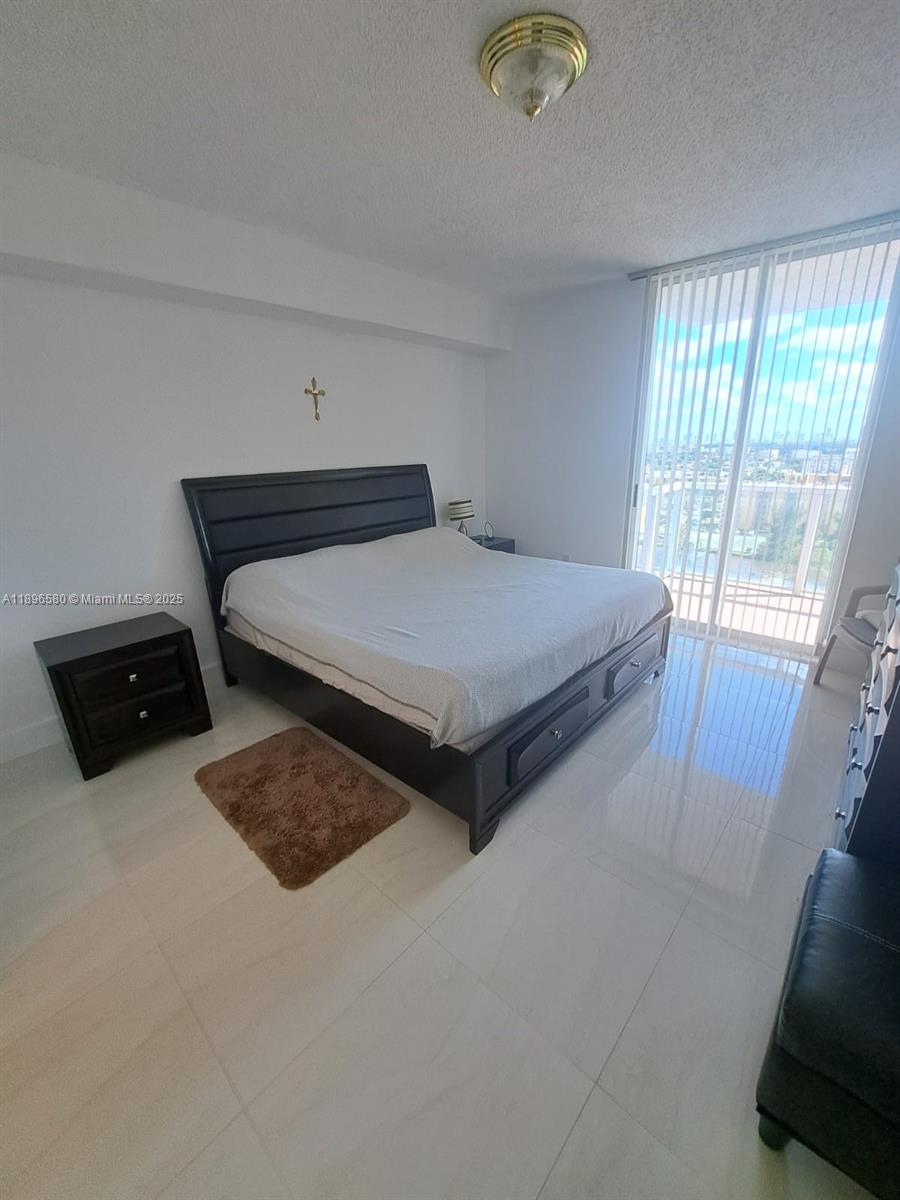 5077 Northwest 7th Street, Unit PH17 Miami, FL 33126 - Photo 6 of 25 a bedroom with bed and window