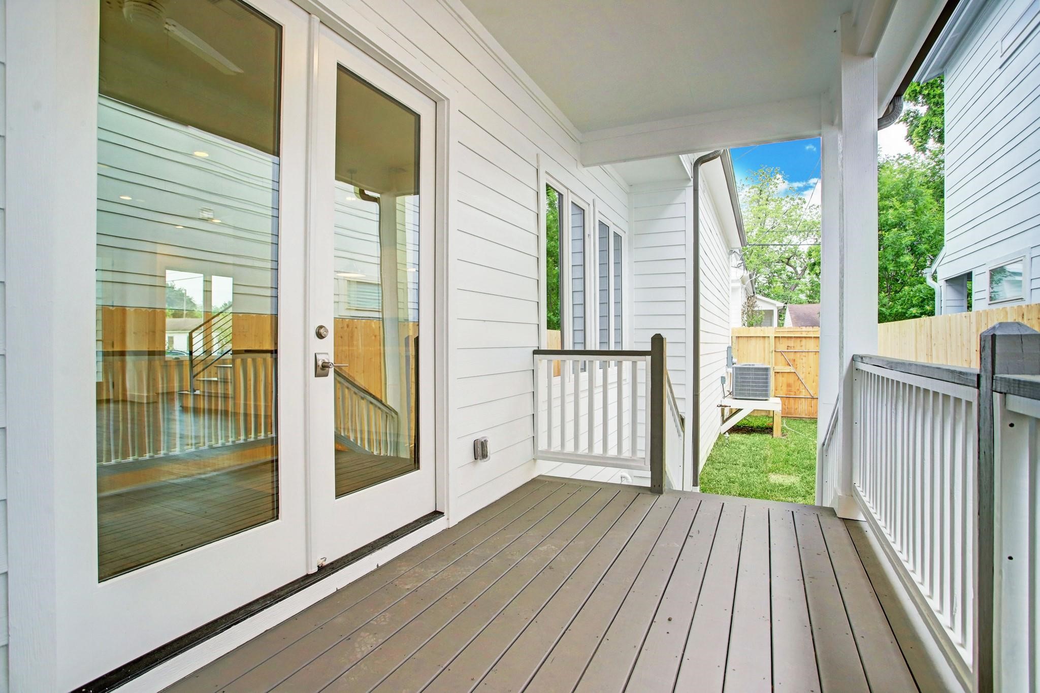 3827 Arlington Street Houston, TX 77018 - Photo 35 of 39 Charming covered back porch with white siding and French doors, leading to a small fenced yard. Ideal for relaxing or entertaining.