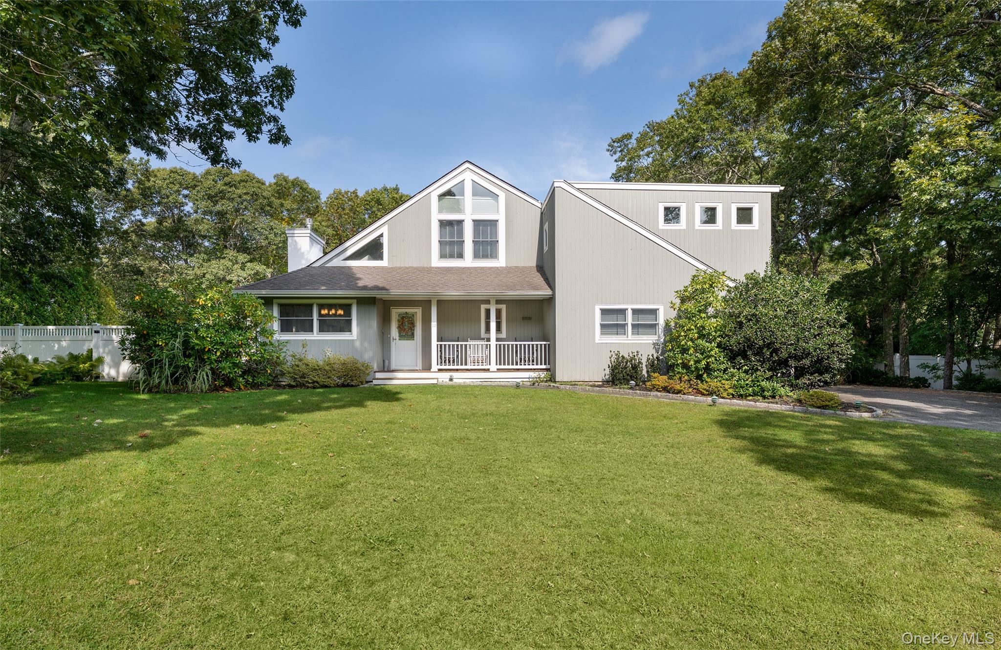 a front view of a house with a yard and trees