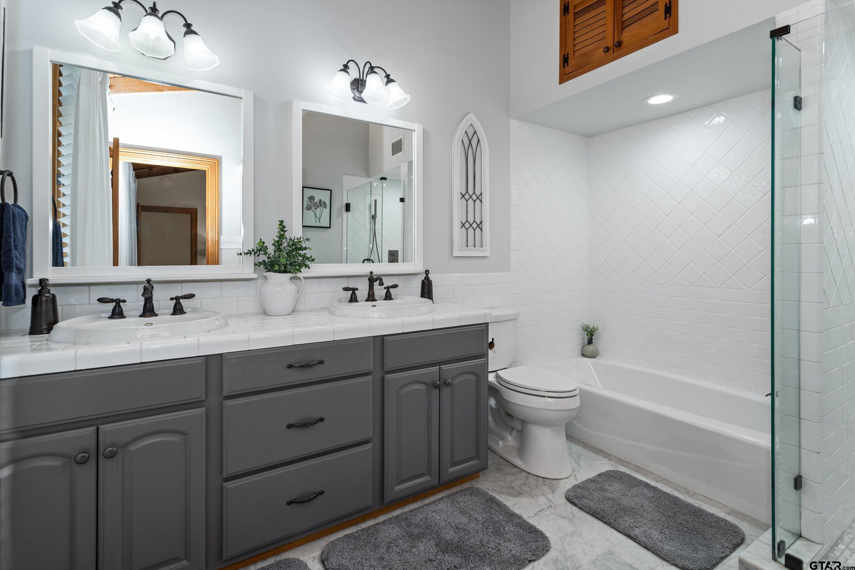 129 Tejas Trail Grapeland, TX 75844 - Photo 24 of 47 a bathroom with a double vanity sink toilet mirror and bathtub
