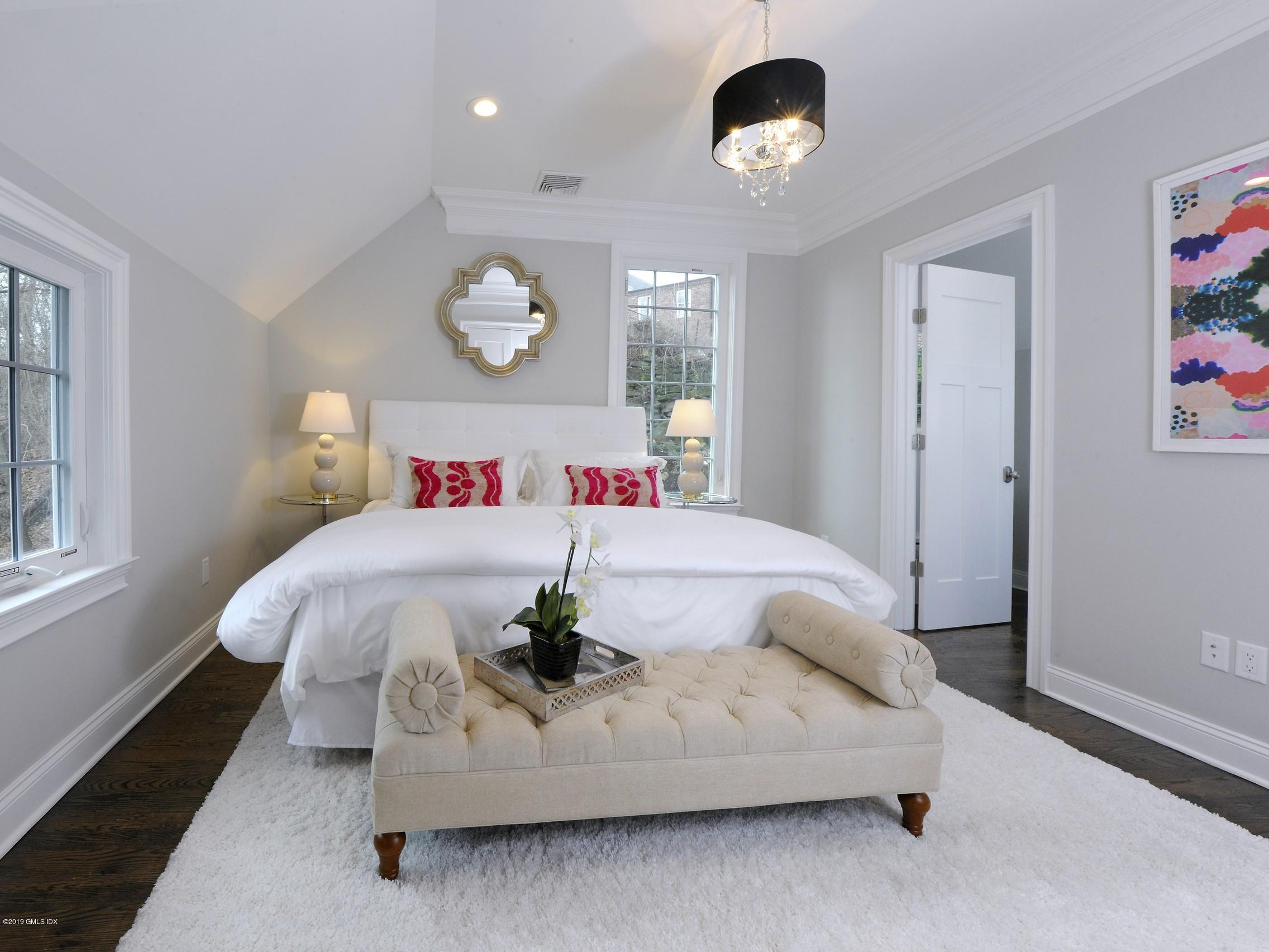 200 Davis Avenue Greenwich, CT 06830 - Photo 18 of 26 a bed room with a bed and a chandelier