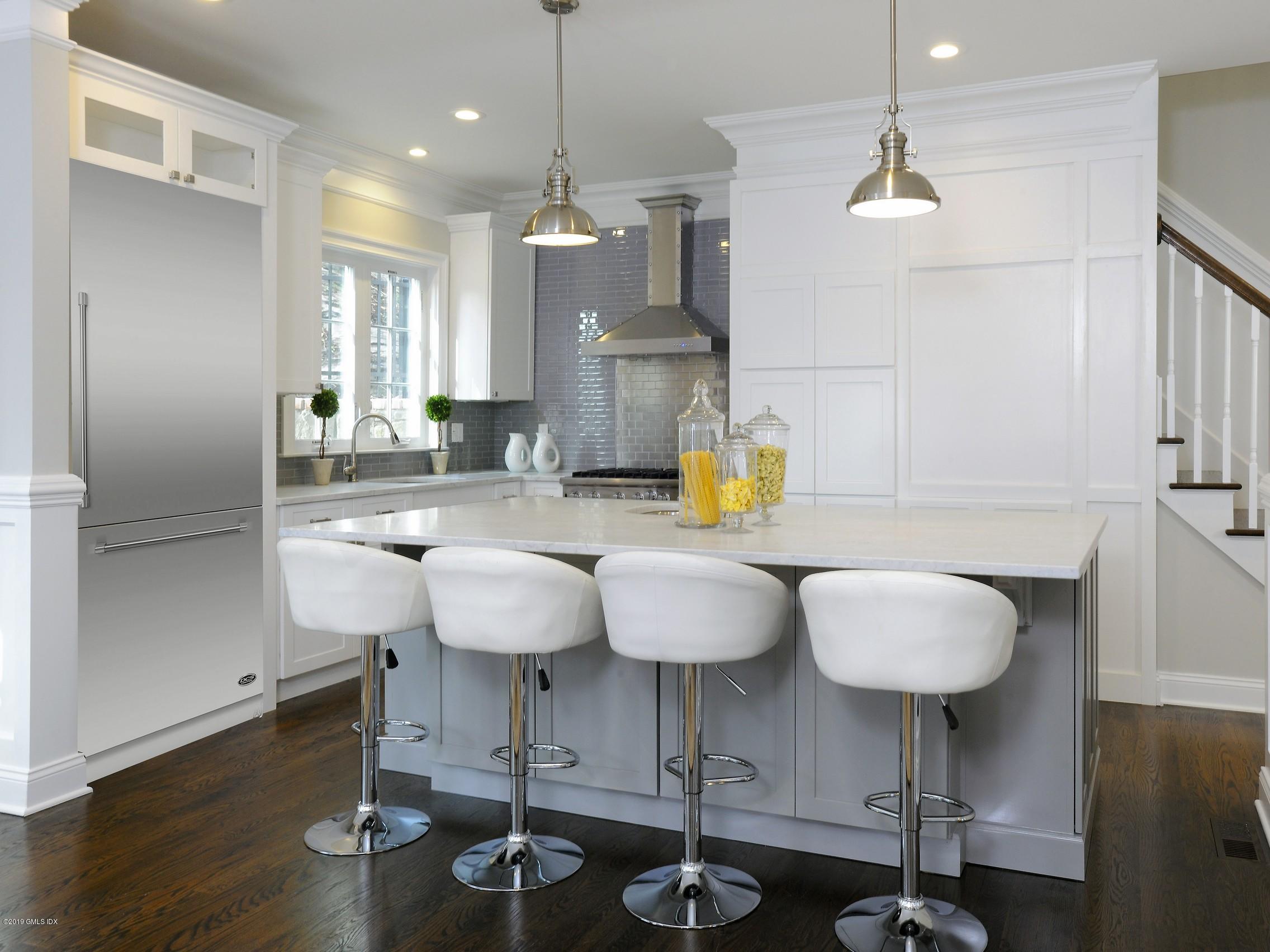 200 Davis Avenue Greenwich, CT 06830 - Photo 8 of 26 a kitchen with stainless steel appliances kitchen island granite countertop a table chairs and a refrigerator