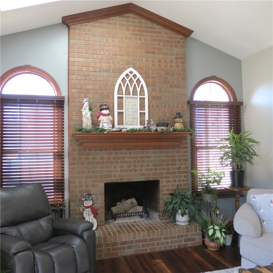 10160 Lochard Road Sidney, OH 45365 - Photo 10 of 41 This inviting living space features a cozy brick fireplace, perfect for gatherings and relaxation.
