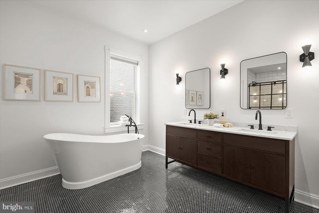 a spacious bathroom with a double vanity sink mirror and bathtub