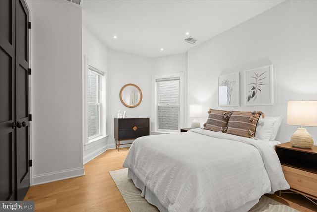 a bed room with a bed mirror and a table