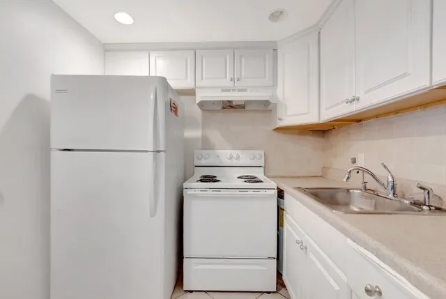 a kitchen with a refrigerator sink stove and cabinets