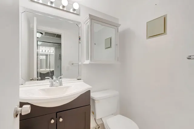 a bathroom with a toilet sink and mirror
