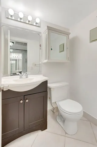a bathroom with a sink a toilet and mirror