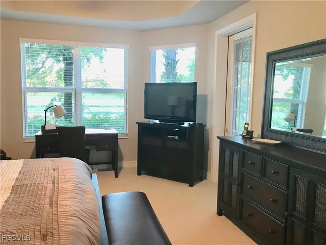 a bedroom with a bed and large windows