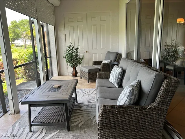 a living room with furniture fireplace and a large window