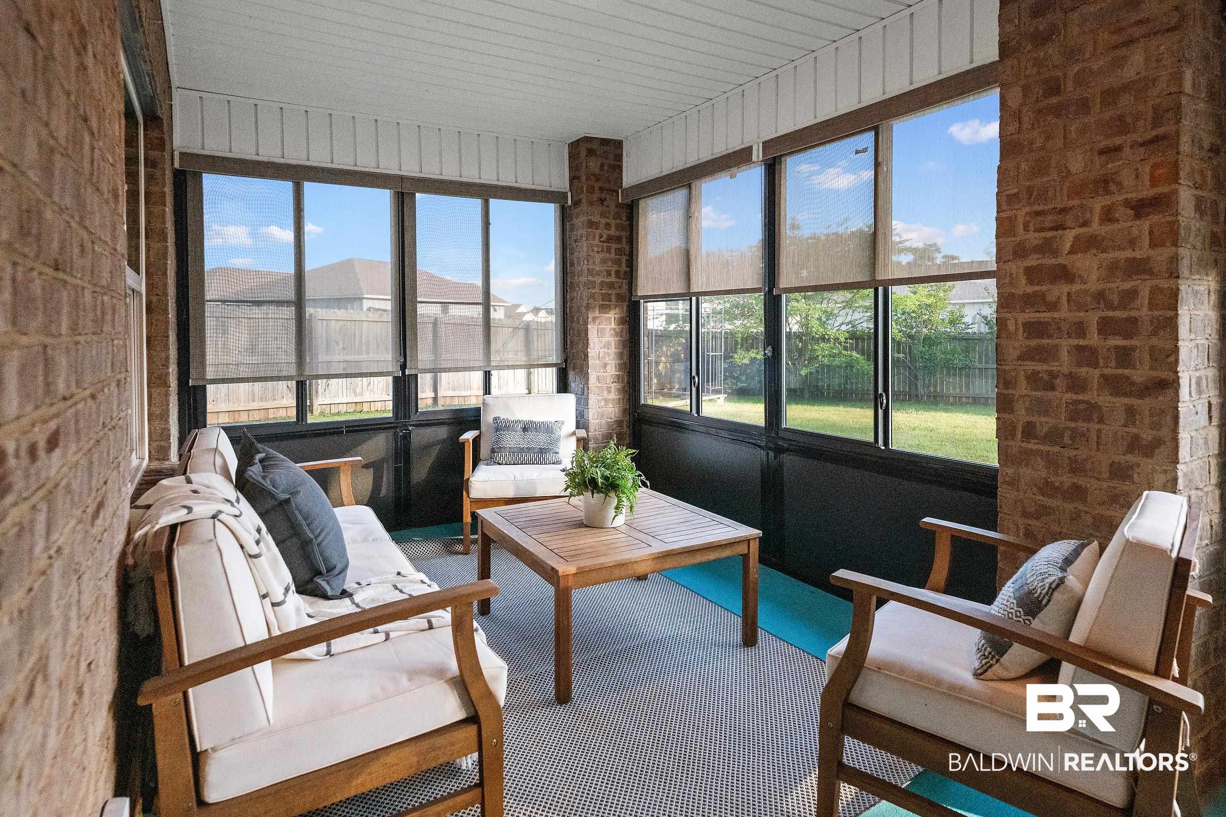 8294 Irwin Loop Daphne, AL 36526 - Photo 21 of 29 Screened porch featuring brick accents, a paneled ceiling, and roll-down window screens