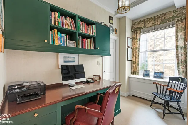 a view of a workspace with furniture and a bookshelf