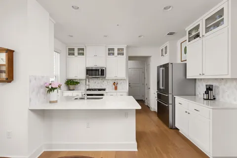a kitchen with stainless steel appliances a sink stove refrigerator and cabinets