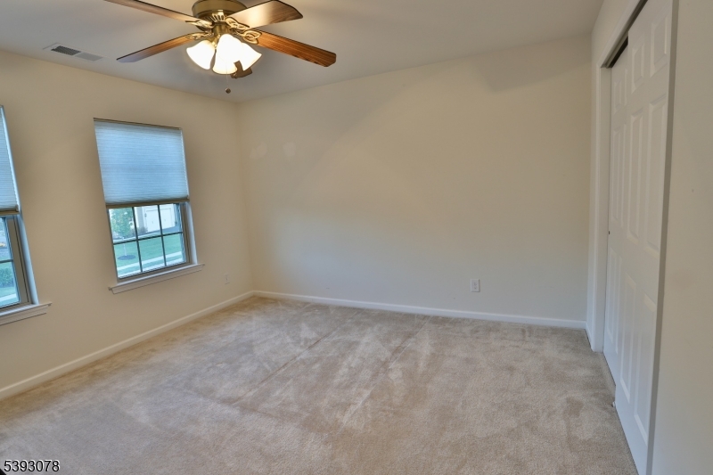 18 Barnett Road Flemington, NJ 08822 - Photo 20 of 25 an empty room with a chandelier fan and windows