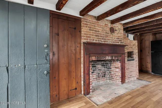 a view of a livingroom with wooden floor and a fireplace