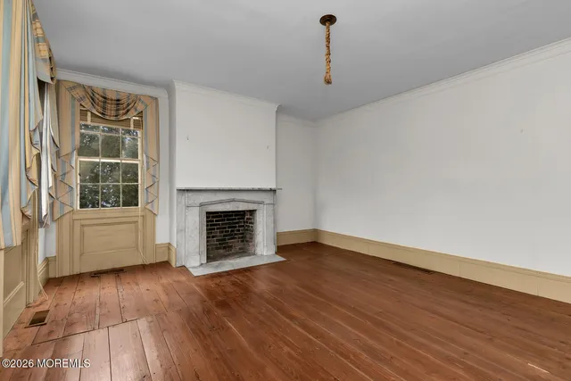 a view of a livingroom with wooden floor and a fireplace