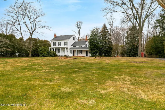 a front view of residential houses with yard and trees
