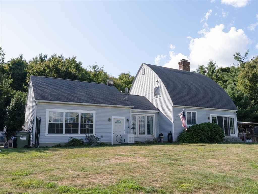 a view of a house with a patio and a yard