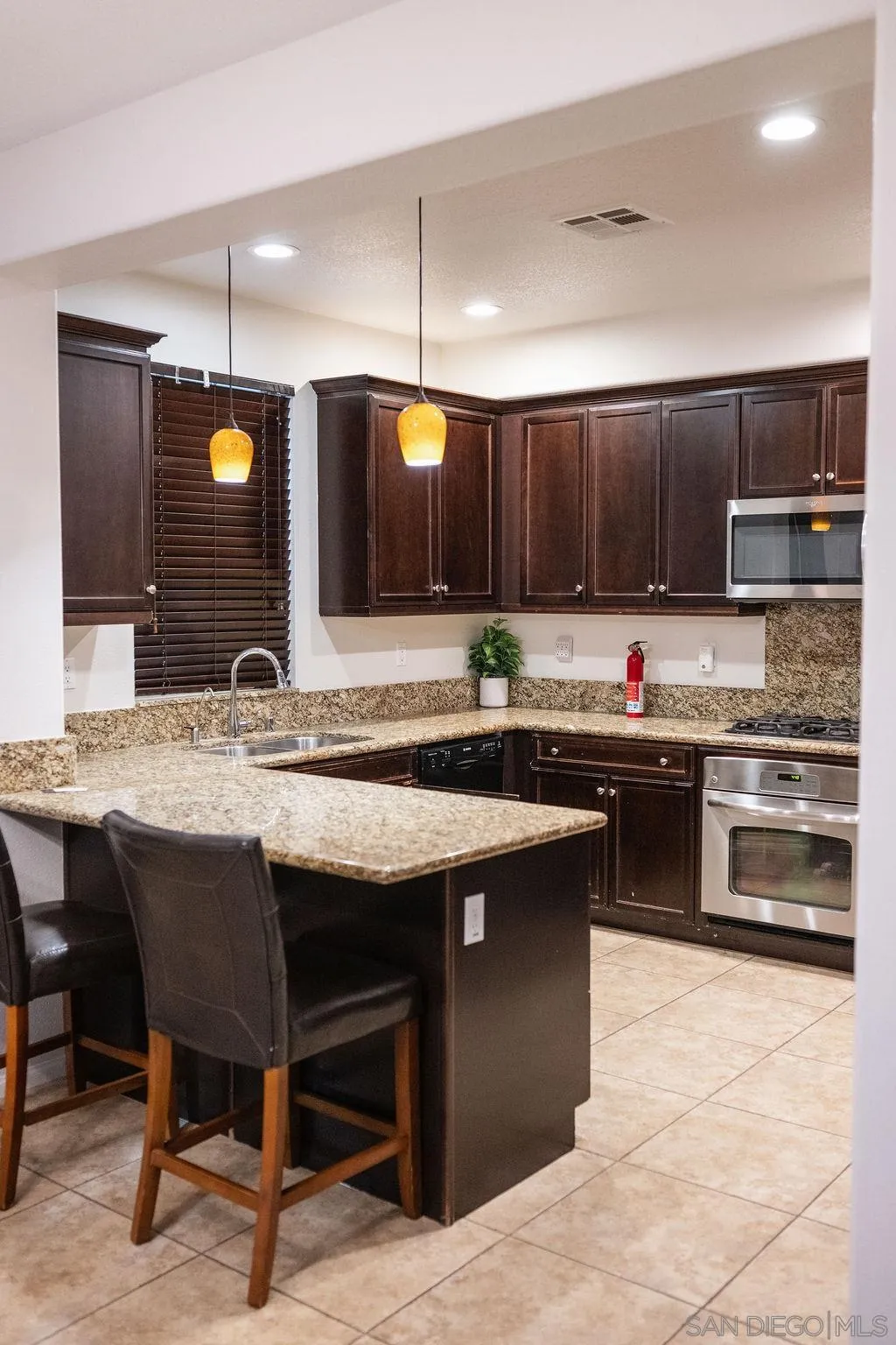 1808 Cyan Lane Chula Vista, CA 91913 - Photo 18 of 43 a kitchen with kitchen island granite countertop a sink counter and chairs
