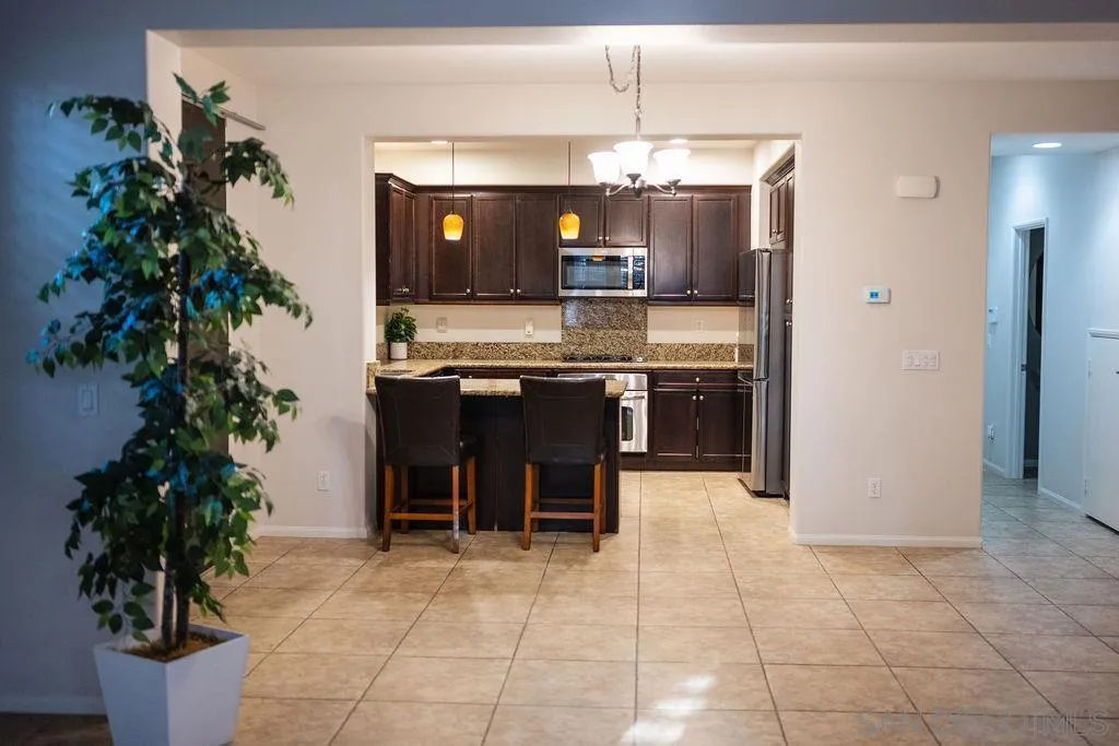 1808 Cyan Lane Chula Vista, CA 91913 - Photo 2 of 43 a kitchen with granite countertop a sink and chairs in it