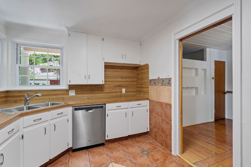 1212 Bentwood Road Austin, TX 78722 - Photo 12 of 32 a kitchen with white cabinets and sink