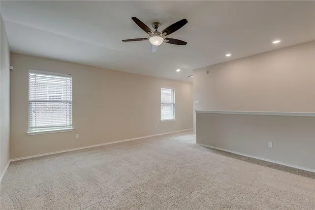an empty room with ceiling fan and window