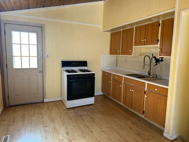 a kitchen with stainless steel appliances granite countertop a stove a sink and a refrigerator