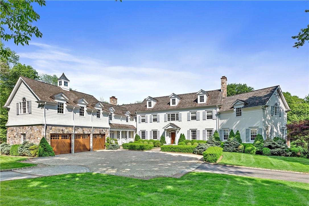 a front view of a house with a garden and yard